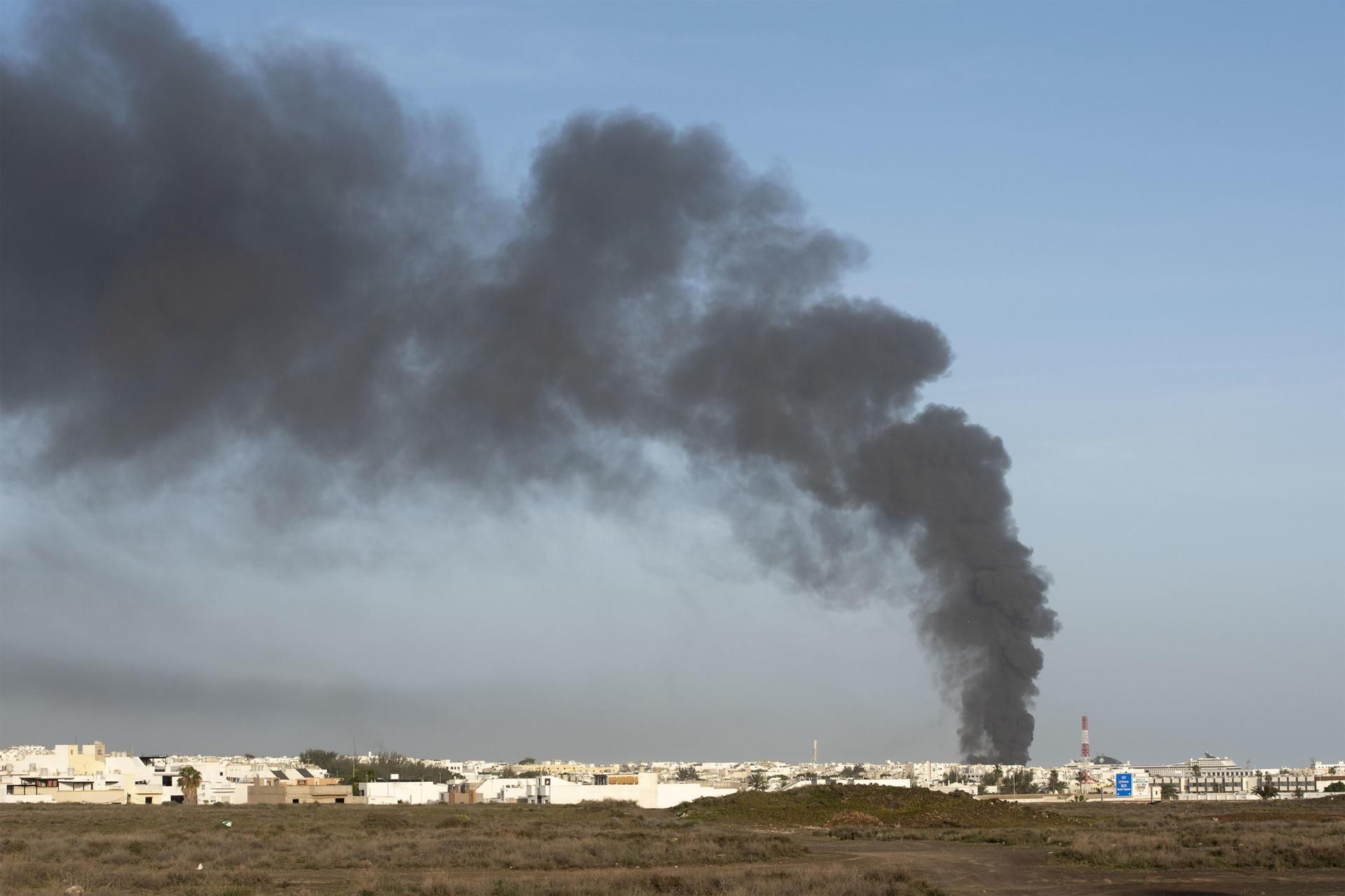 Columna de humo negro del incendio declarado este lunes por la tarde en la nave de Lanzarote Bus en Arrecife.
