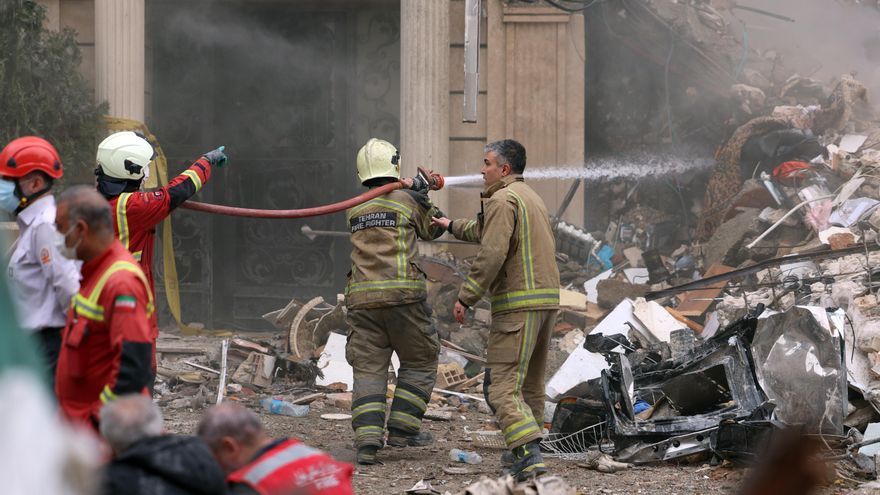 Bomberos trabajan en el lugar de los edificios residenciales dañados en el norte de Teherán, Irán.