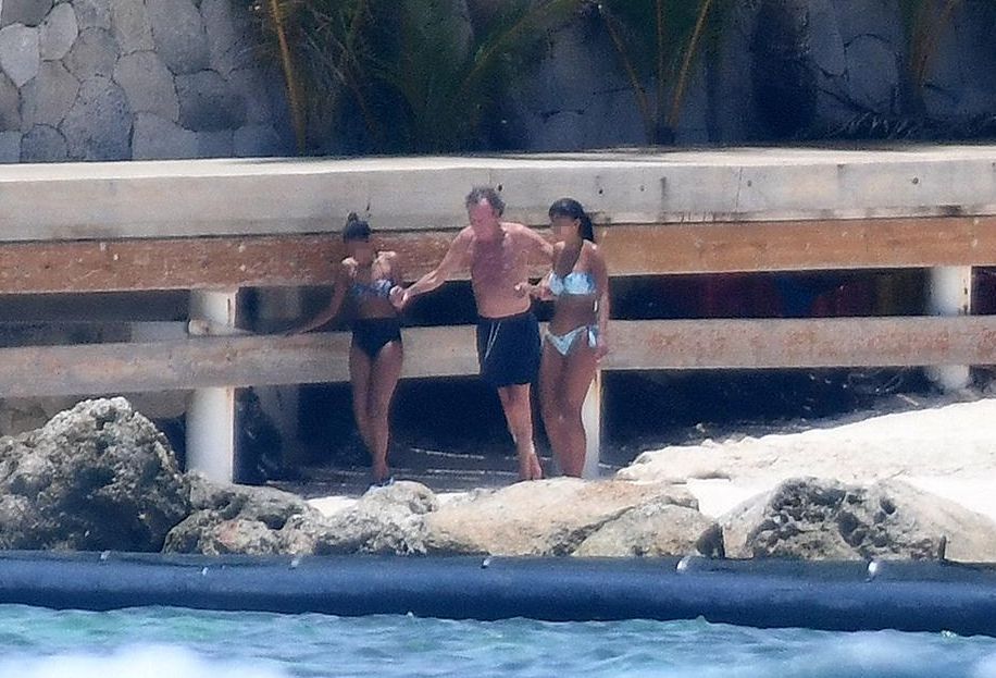 Julio Iglesias y dos acompañantes que le ayudan a entrar al mar en la playa de Punta Cana en 2020. 