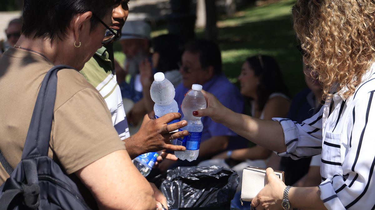 Varias personas beben agua para protegerse del calor. EFE/ Pablo R. Seco