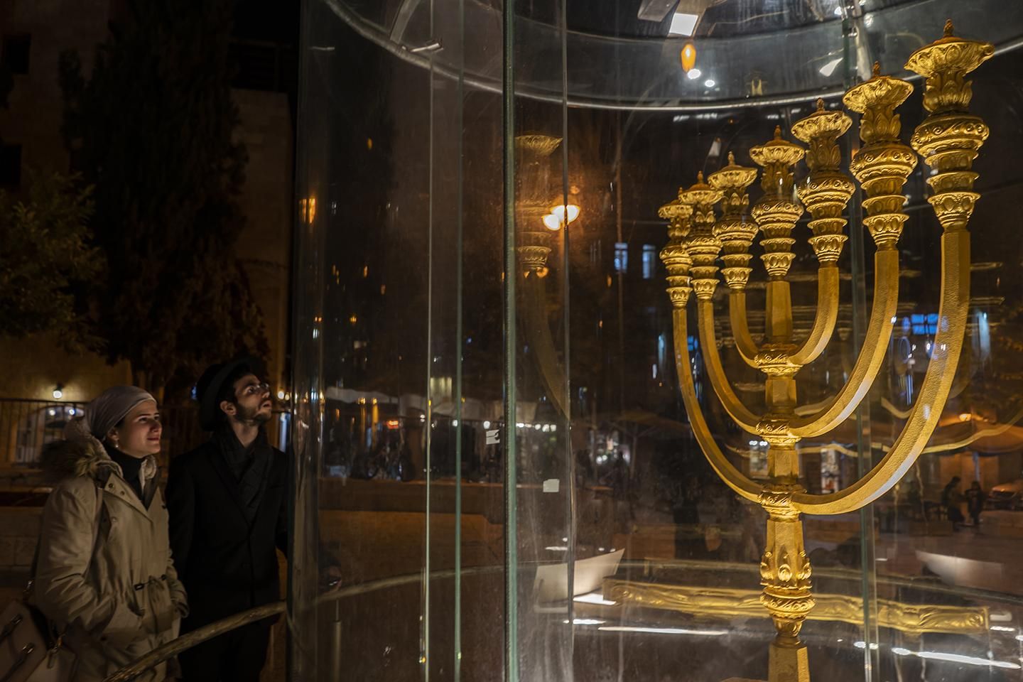 Una pareja de judíos observa el Golden Menorah, uno de los símbolos del judaísmo. | JOAQUÍN GÓMEZ SASTRE