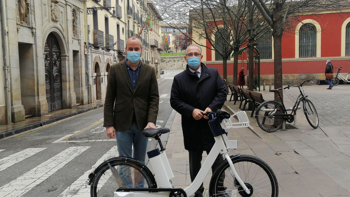 Fermín Alonso y Enrique Maya con una de las bicicletas del nuevo servicio del Ayuntamiento de Pamplona