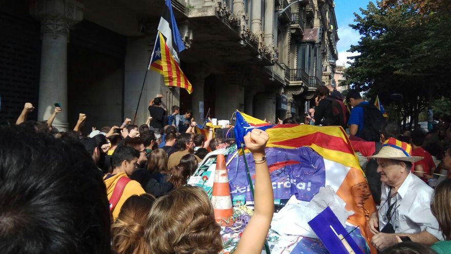 Manifestantes cubren con banderas uno de los coches de la Guardia Civil el 20S de 2017.