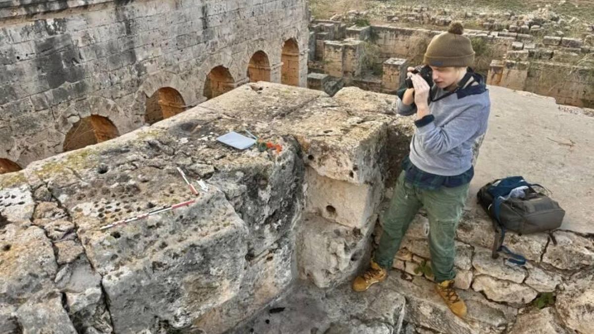 La arqueóloga Zofia Kowarska fotografía algunos de los tableros de juego que fueron tallados en las ruinas de Ptolemaida.