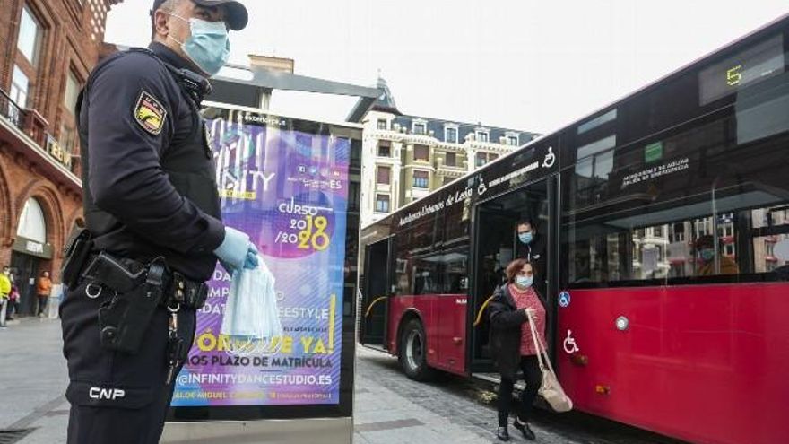 La Policía Nacional reparte mascarillas en la parada del autobús de Santo Domingo en León. / Campillo / ICAL