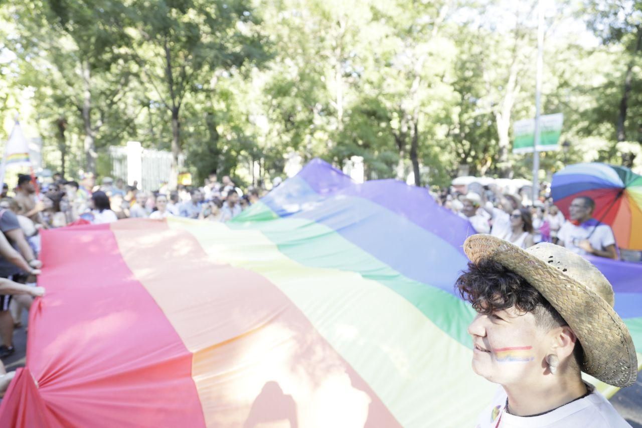 Manifestantes sostienen una gran bandera LGTBI / Marian León