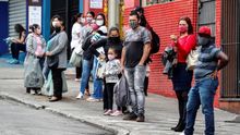 Personas con tapabocas esperan para tomar un bus de transporte público en Sao Paulo (Brasil).