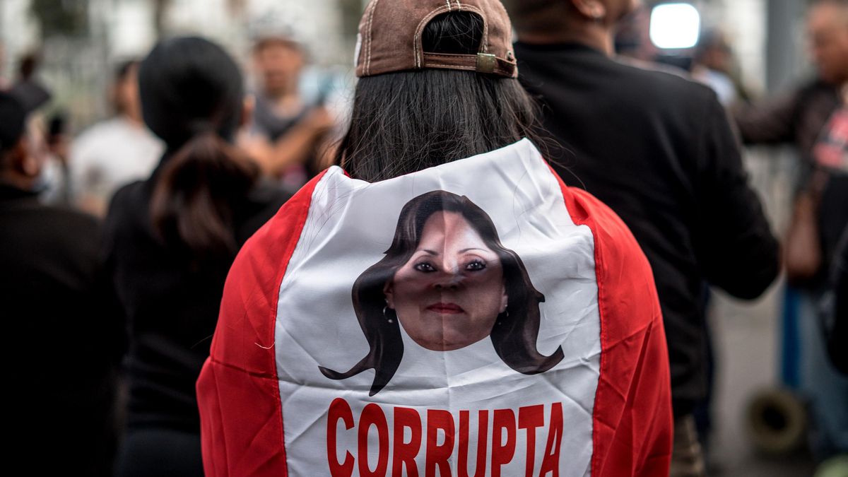 Una persona sostiene una bandera de Perú con la imagen de la presidenta, Dina Boluarte, durante una manifestación este jueves, en Lima (Perú).