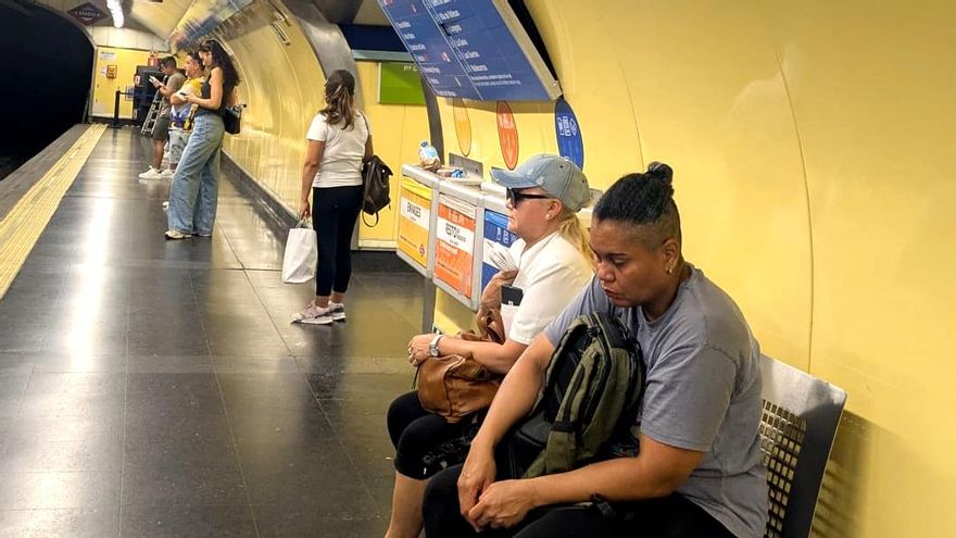 Una mujer soporta el calor con su pequeño ventilador de mano