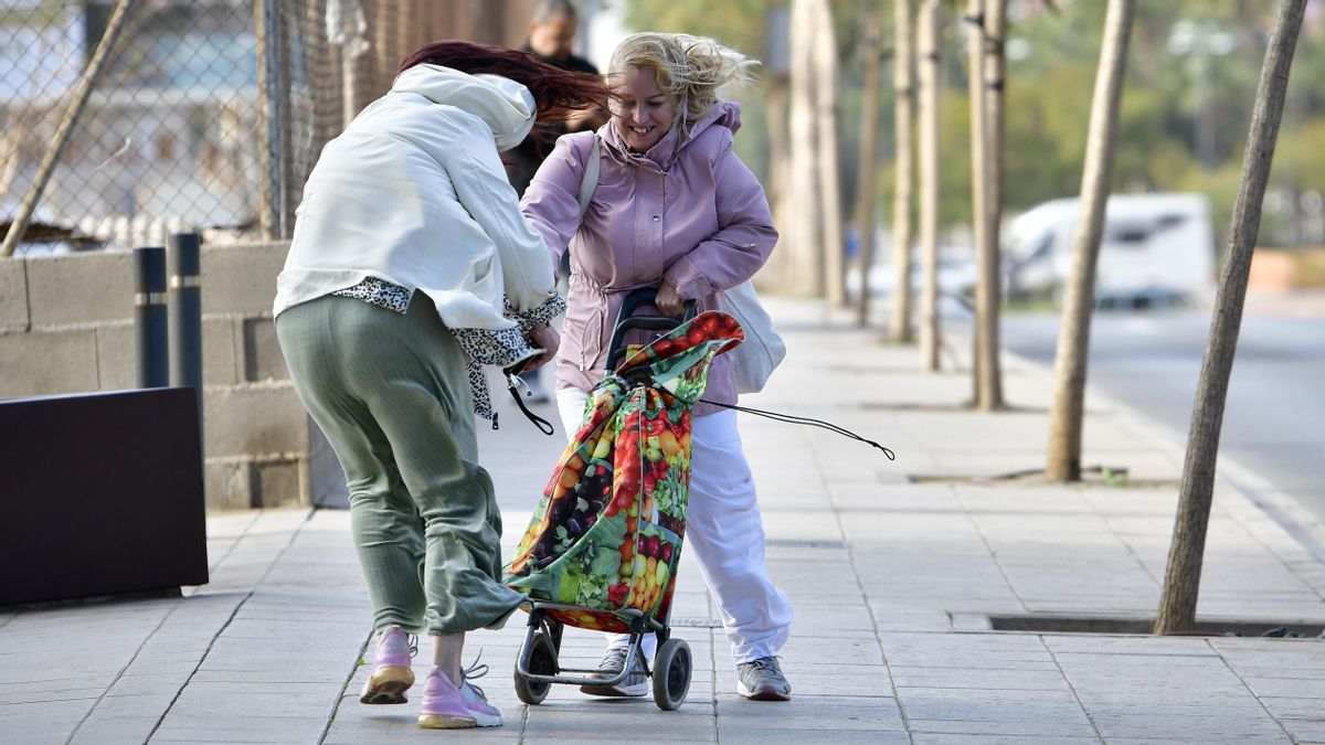 Varias personas intentan caminar mientras sopla fuertemente el viento en Almería