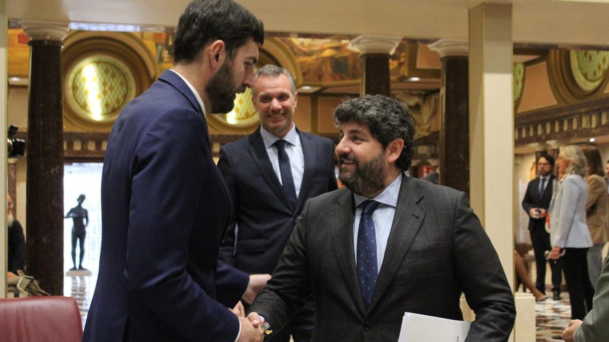 El presidente provincial de Vox en la Región de Murcia, José Ángel Antelo, le da la mano al presidente del Ejecutivo murciano, Fernando López Miras