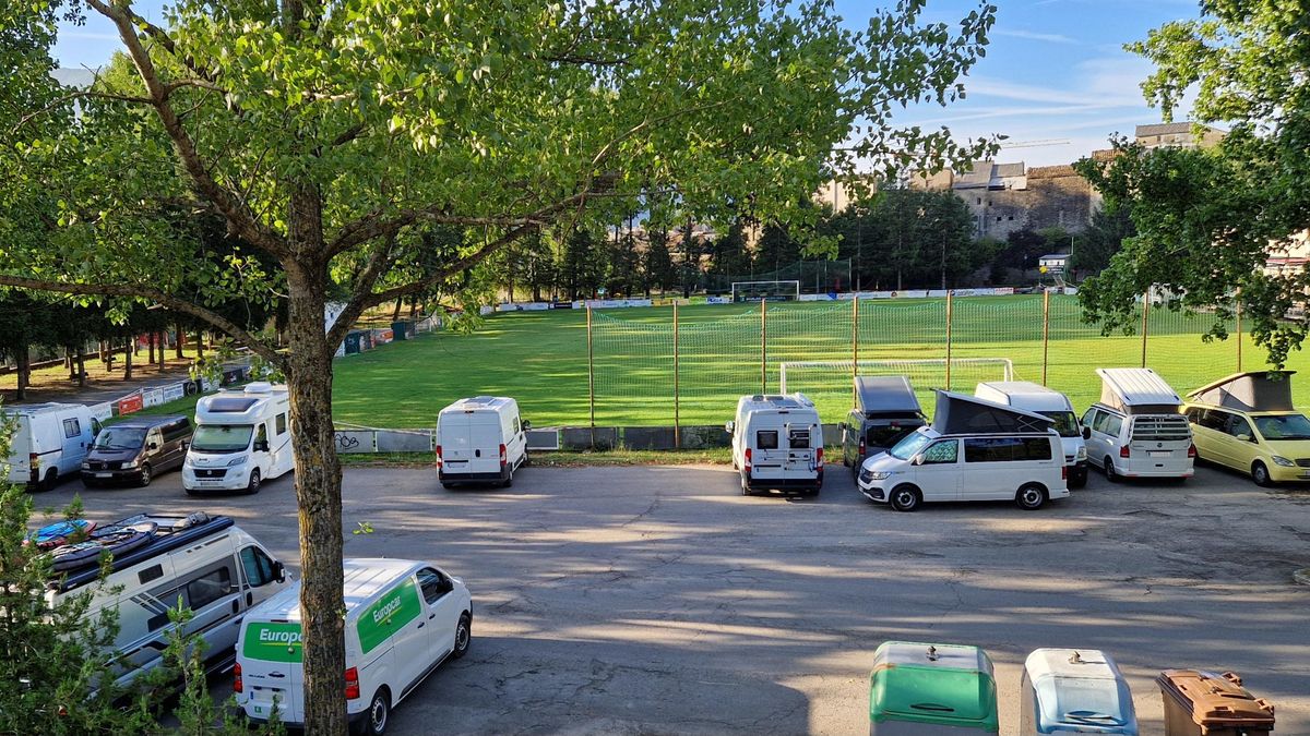 Autocaravanas y furgonetas aparcadas al lado del campo de fútbol de Biescas