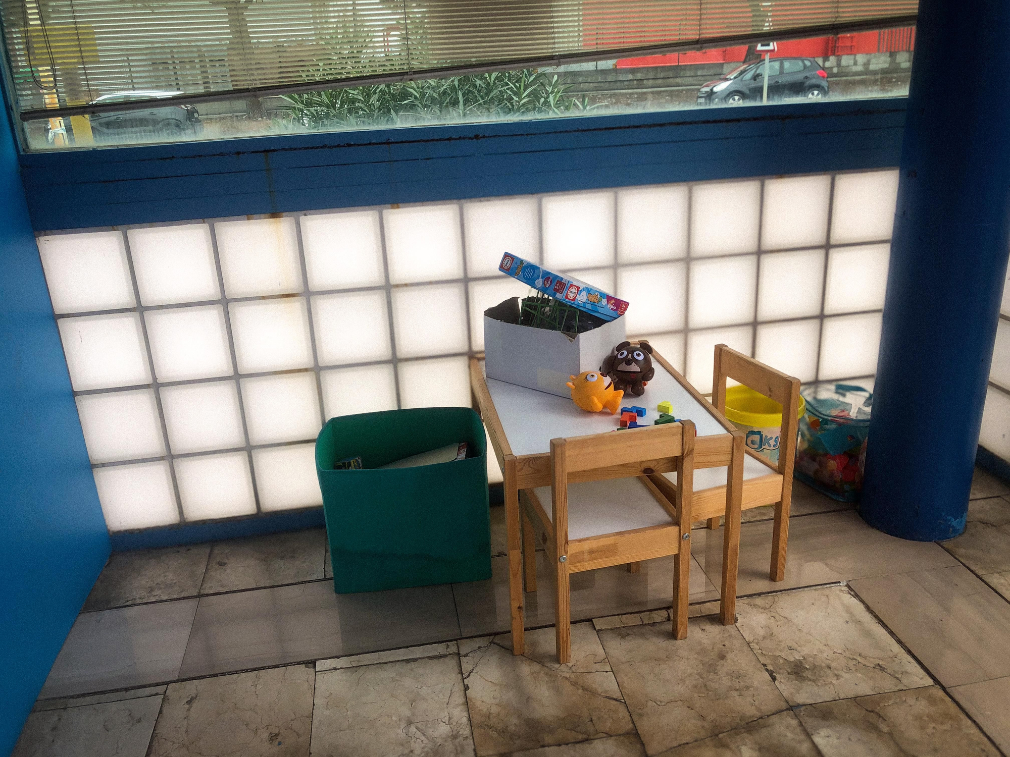 La sala de espera del Centro de Internamiento de Extranjeros de Barcelona, situada bajo una carpa blanca y azul, dispone de un lavabo, sillas y algunos juegos infantiles