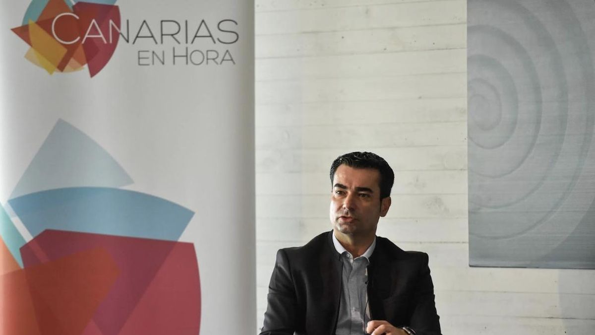 El exadministrador único de Etiazul, Pedro Guerra, ante el logo de la marca Canarias en Hora, por la que ha de indemnizar a Canarias Ahora.