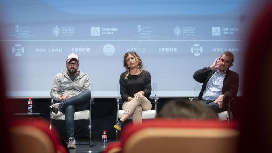 Los tres intervinientes escuchan una de las preguntas del público.