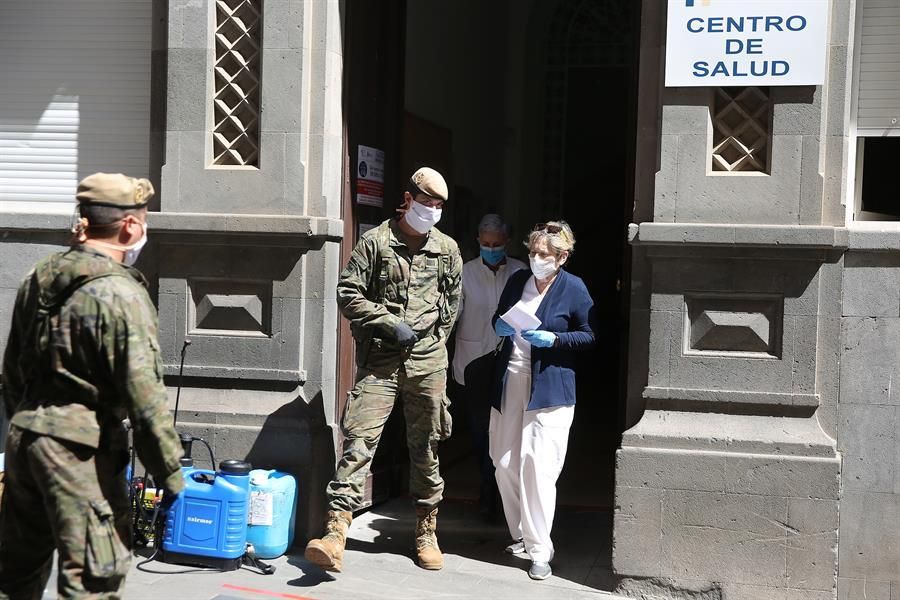 Efectivos del Ejército de Tierra, con trajes de protección, realizan labores de desinfección en el centro de salud de la zona centro de Santa Cruz