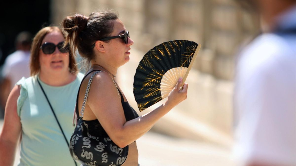 Una mujer intenta aliviar el calor con el abanico en Málaga.