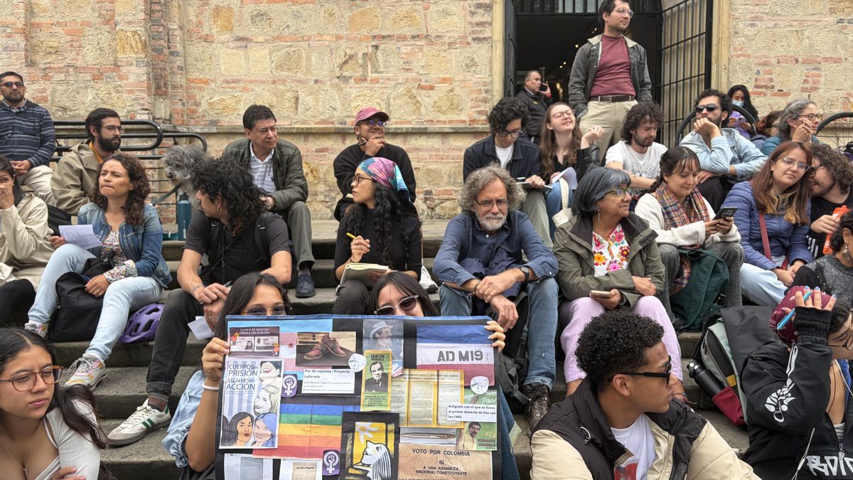 Asistentes a la clase de López muestran, en las escalinatas del Museo Nacional, un collage con las piezas retiradas: el brazalete de la AD M-19, la Séptima Papeleta, el afiche de Bernardo Jaramillo y el bolígrafo con el que se firmó el acuerdo de paz con las FARC