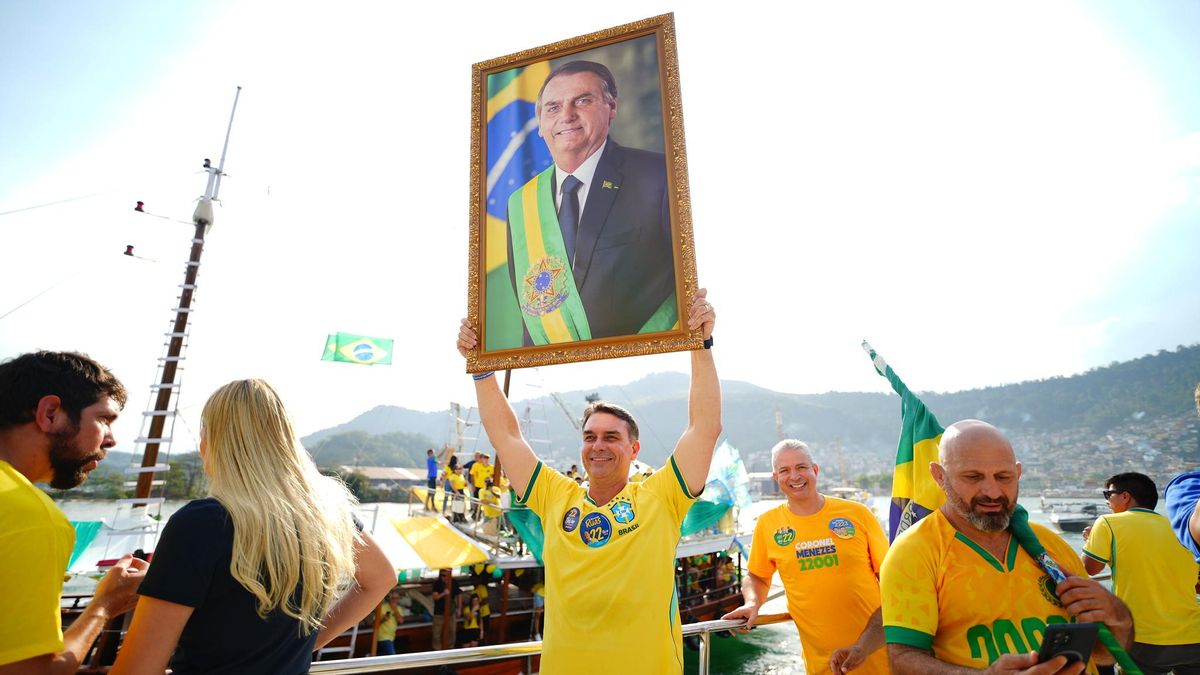 El candidato ultraderechista brasileño Flávio Bolsonario (centro), con una foto enmarcada de sus padres en un mitin en barco en Angra dos Reis.
