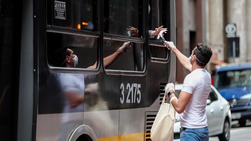 Voluntarios entregan hoy, miércoles 1 de julio de 2020, mascarillas durante una operación de Vigilancia Sanitaria para fiscalizar y advertir sobre el uso obligatorio para prevenir el contagio del COVID-19, en el centro de Sao Paulo (Brasil).