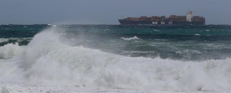Un portacontenedores permanece fondeado en la bahía de Las Palmas de Gran Canaria mientras el fuerte oleaje azota el litoral