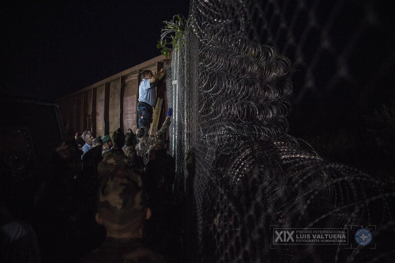 Policías y soldados húngaros colocan el final de la valla que sella el paso fronterizo de Roszke, por donde entraban las personas refugiadas al país. (Roszke. Hungría. 14/09/2015). | Foto: Olmo Calvo.