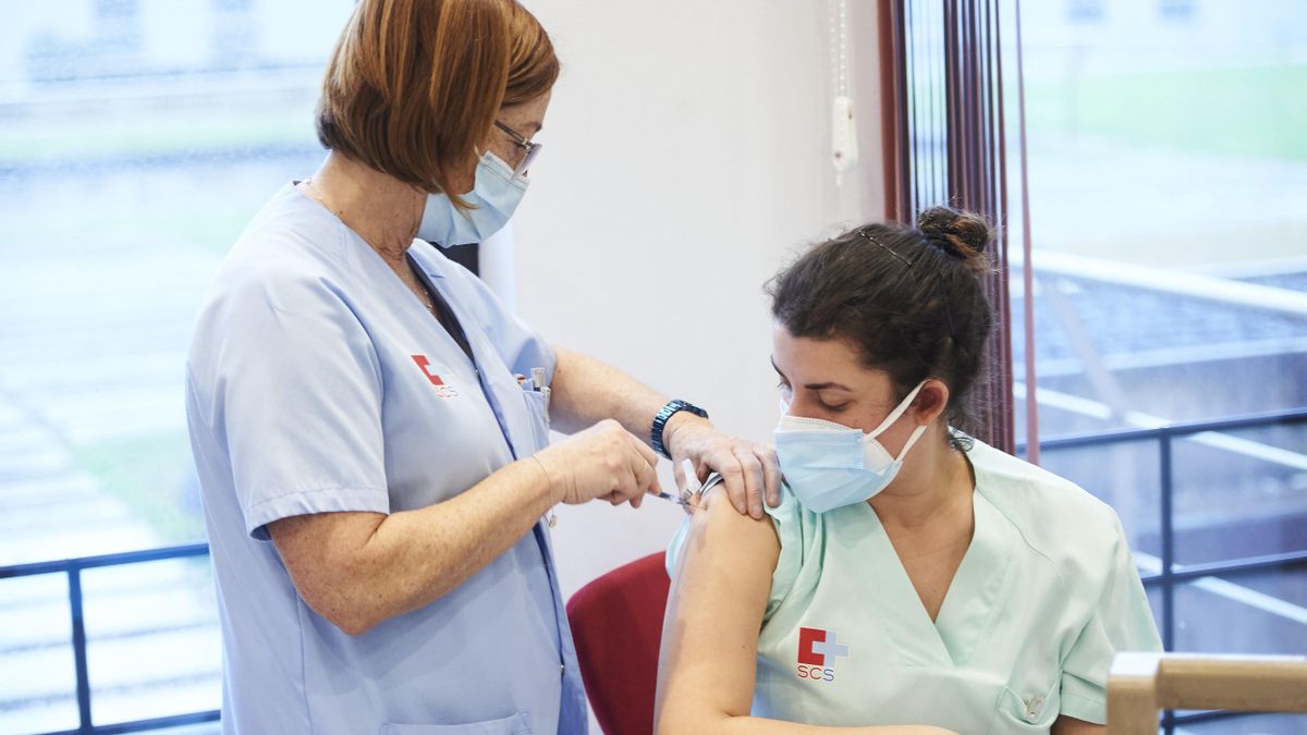 Un trabajadora sanitaria inyecta la segunda dosis de la vacuna de Pfizer-BioNTech contra la Covid-19 a una sanitaria del Hospital Universitario Marqués de Valdecilla