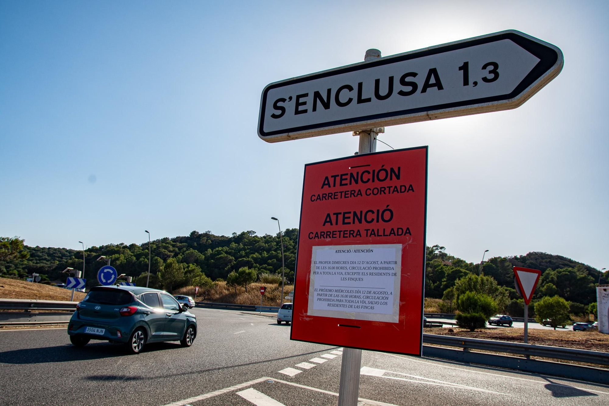 Un cartel advierte del corte de la carretera en S’Enclusa durante la jornada del eclipse solar en Menorca