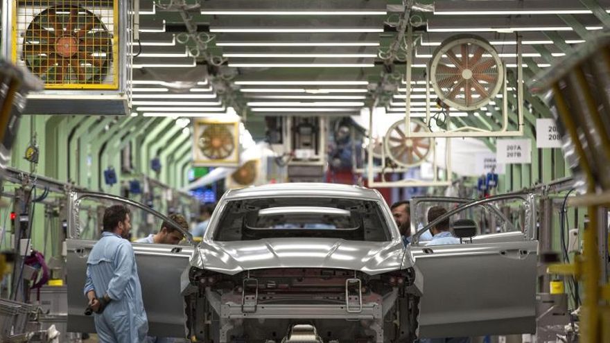 Varios trabajadores de la planta de pintura de Ford en Almussafes (Valencia), revisan una carrocería tras su paso por la zona de pintura.