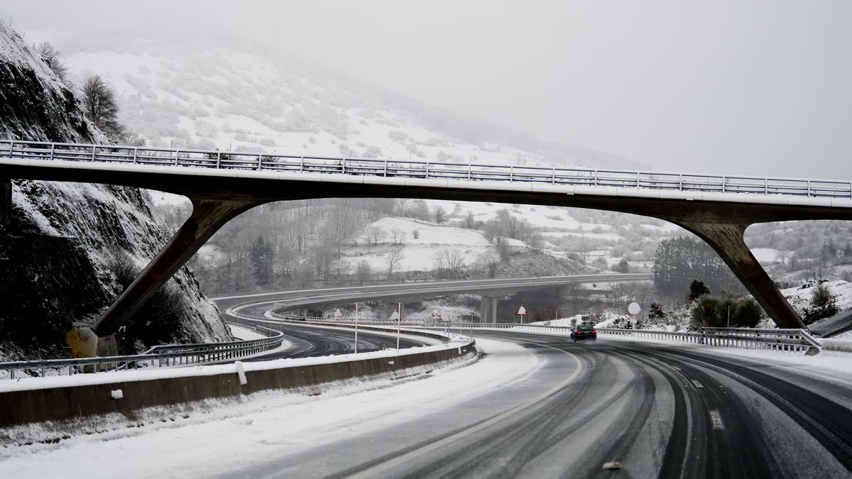 Un coche conduce por una carretera con nieve en Cantabria