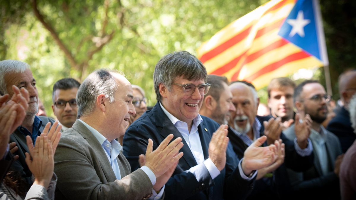 El secretario general de Junts per Catalunya, Jordi Turull (i), y el expresidente de la Generalitat y candidato de Junts a las elecciones catalanas, Carles Puigdemont (d).
