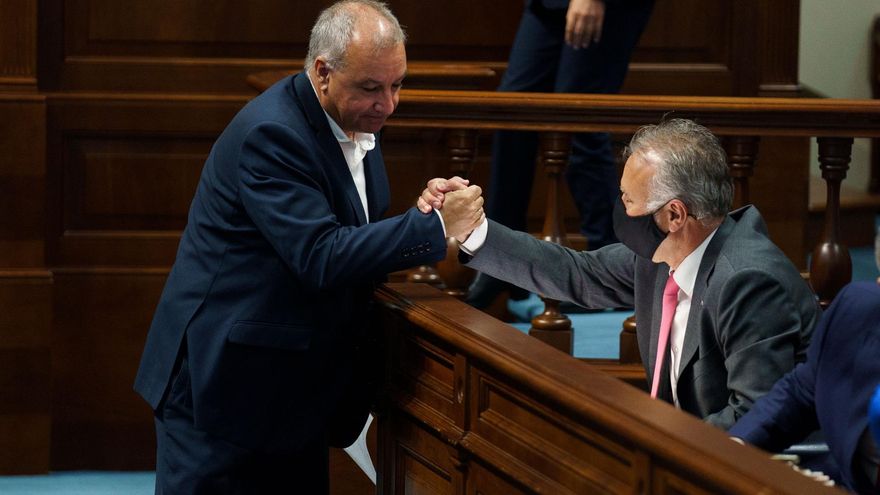 El presidente de Canarias, Ángel Víctor Torres (d), da la mano al portavoz de Nueva Canarias, Luis Alberto Campos (i). EFE/Ramón de la Rocha