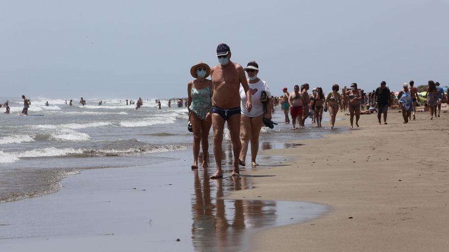 Varias personas pasean por la playa de Las Burras en el segundo día en el que la mascarilla es obligatoria.