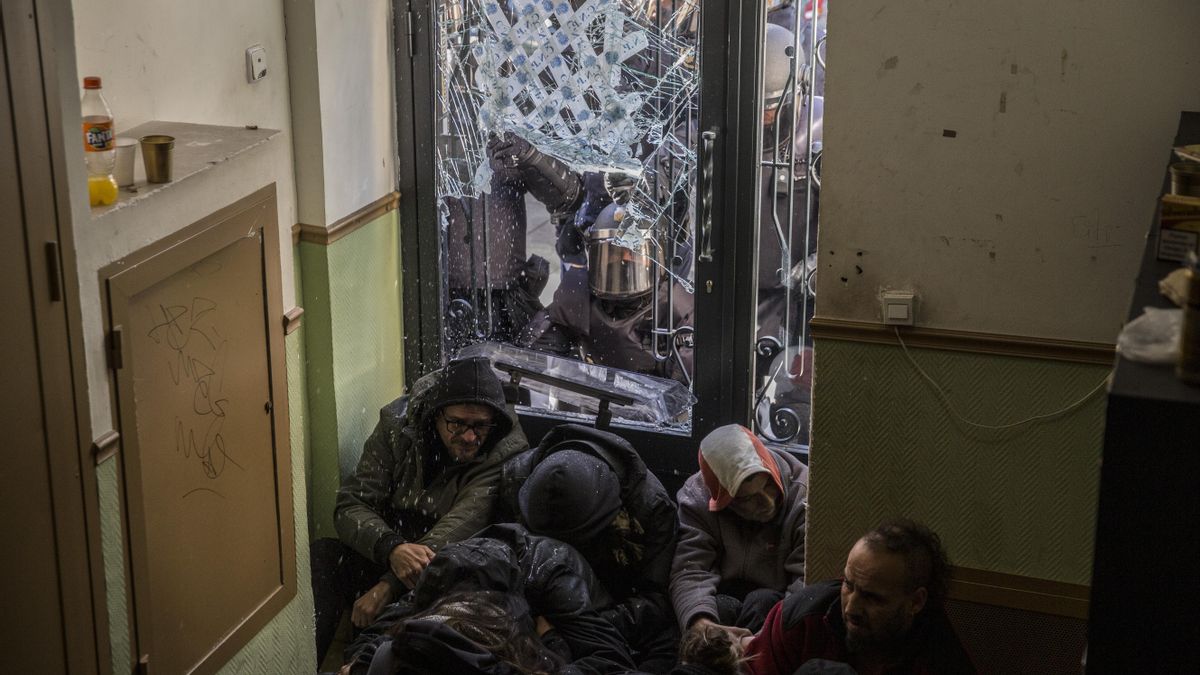 Policías antidisturbios rompen el cristal de la puerta de entrada del edificio ubicado en la calle Argumosa, 11 de Madrid, donde decenas de personas intentaban parar el desahucio de 4 familias, el 22 de febrero de 2019