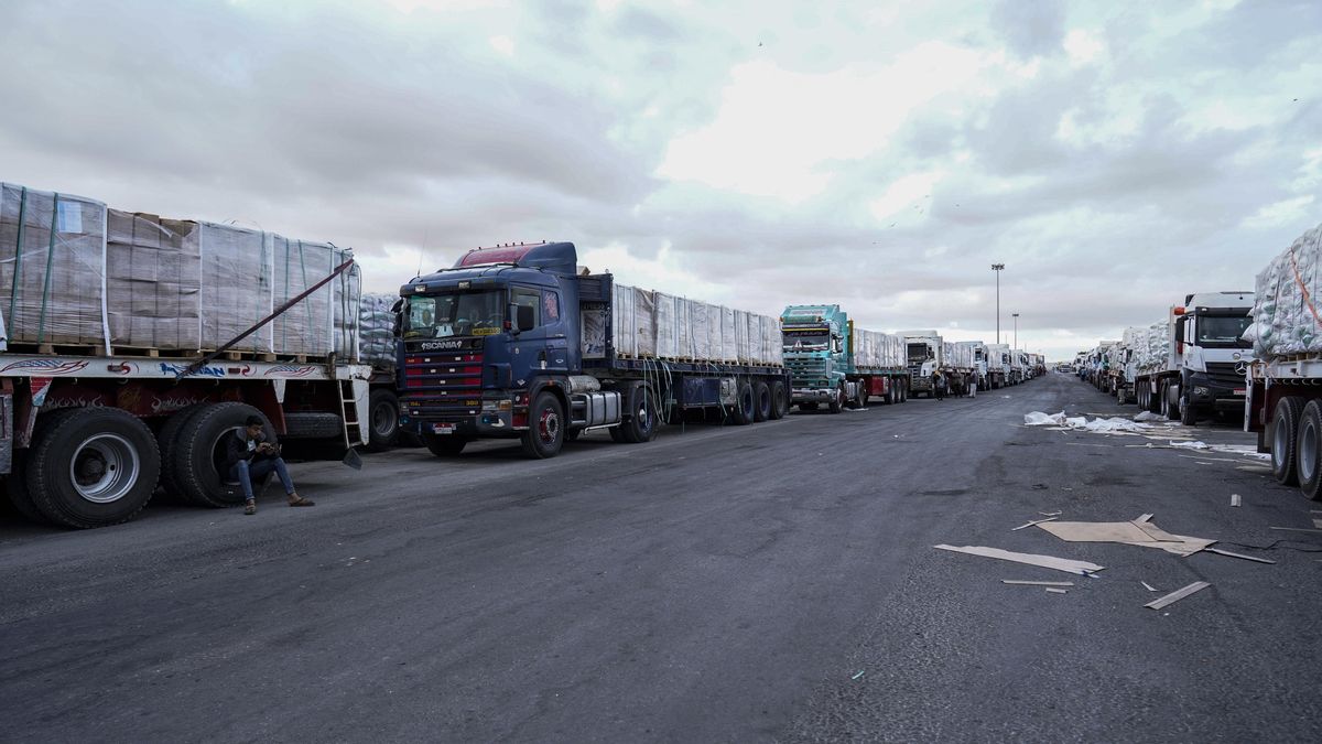 Dozens of vehicles with humanitarian supplies wait on a road near Rafah
