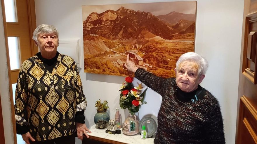 Juanita Fernández y Carmina Iglesias señalan el edificio donde vivían desde la casa de una de ellas en Sant Jordi de Cercs.
