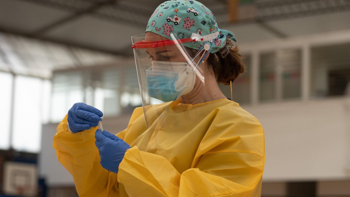 Una sanitaria atiende a una mujer durante las pruebas de cribado de covid-19 con test de antígenos en el pabellón deportivo de 'El Paraguas'. En Sevilla (Andalucía, España), a 28 de octubre de 2020.