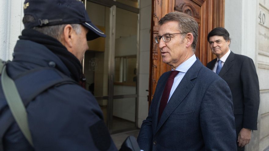 El presidente del PP, Alberto Núñez Feijóo (i) y el diputado del PP Carlos Rojas (d), saludan a un policía nacional