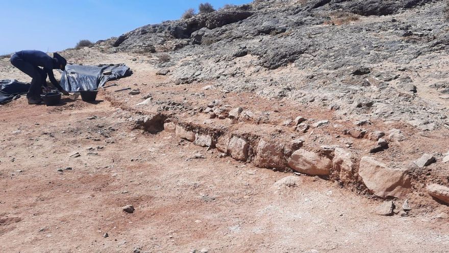 Un arqueólogo junto a una estructura con resto de un muro construido por los normandos
