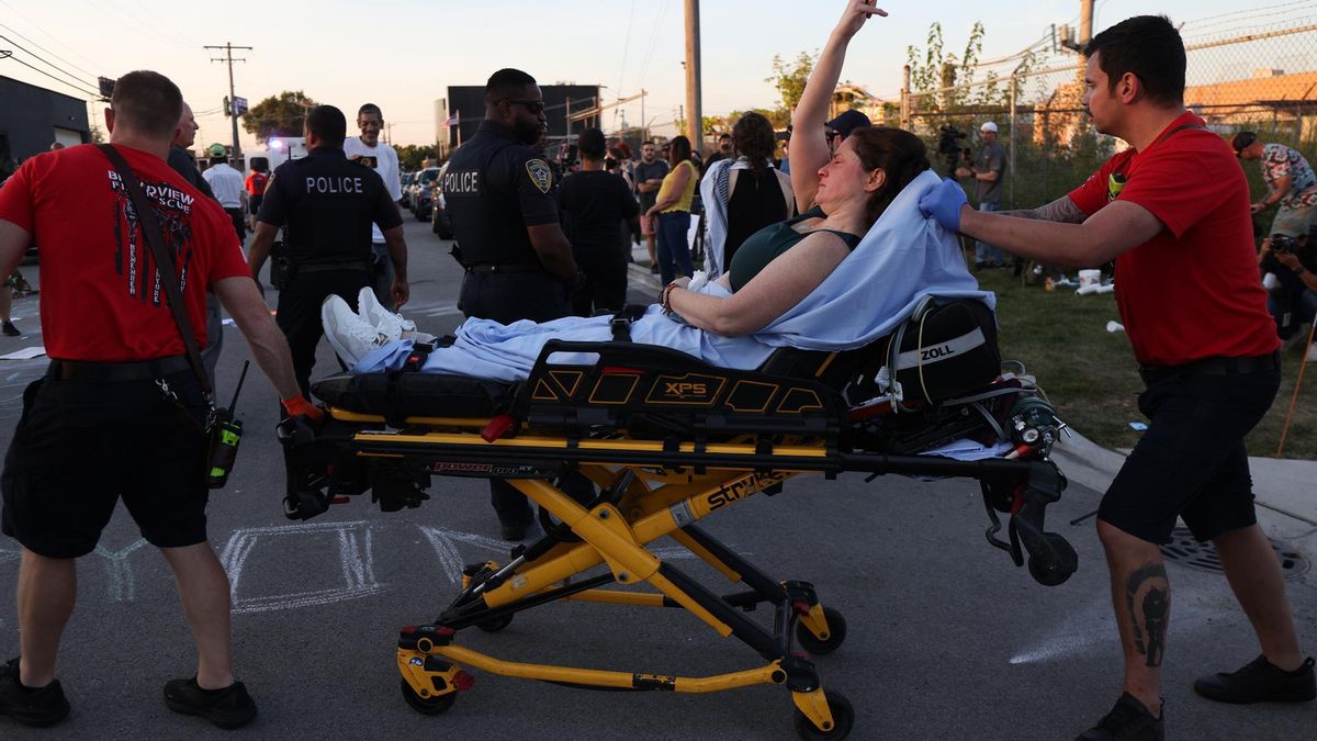 Una joven saca el dedo corazón a un grupo de agentes de policía tras ser evacuada en camilla después de resultar herida en las cargas policiales contra los manifestantes de Broadview.