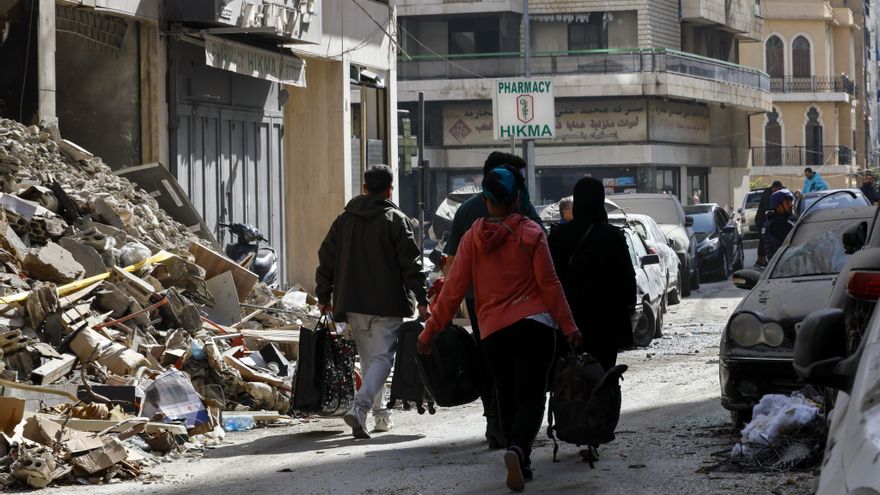 Personas evacuan sus hogares, cargando sus pertenencias, tras un ataque israelí contra un edificio del distrito de Zuqaq al-Blat, en el centro de Beirut.