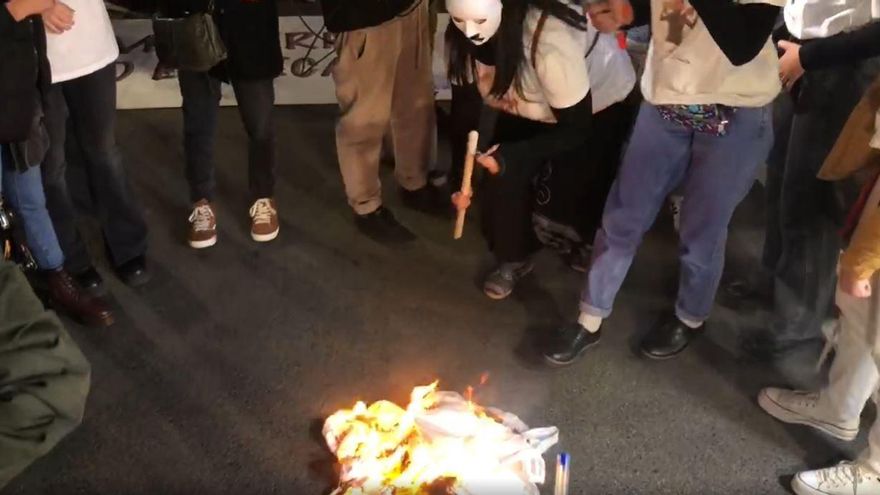 Unas manifestantes queman un velo.