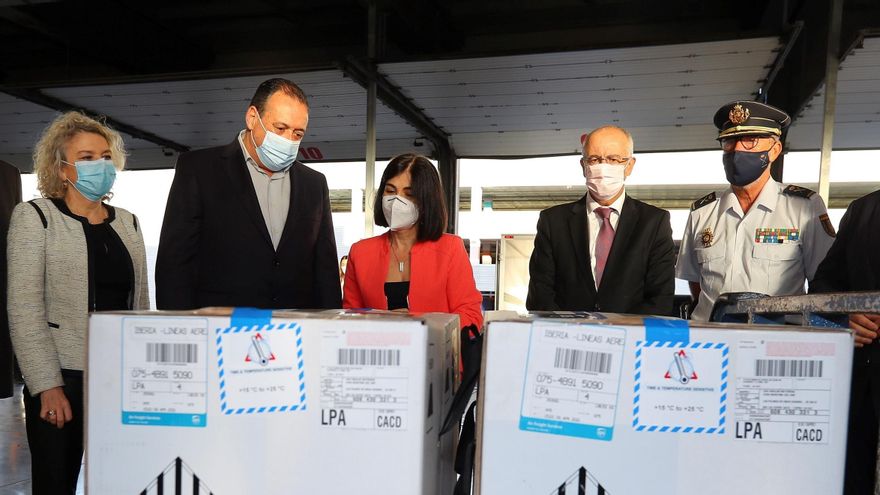 La ministra de Sanidad, Carolina Darias (c), y el consejero de Sanidad del Gobierno de Canarias, Blas Trujillo (3i), asisten este lunes a la descarga de un nuevo envío de vacunas contra la covid-19 de Pfizer/BioNTec en el aeropuerto de Gran Canaria. EFE/ Elvira Urquijo A.