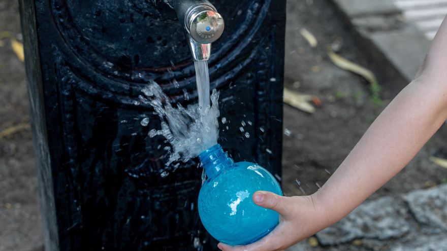 Archivo - Una persona llena un bote de agua en una fuente