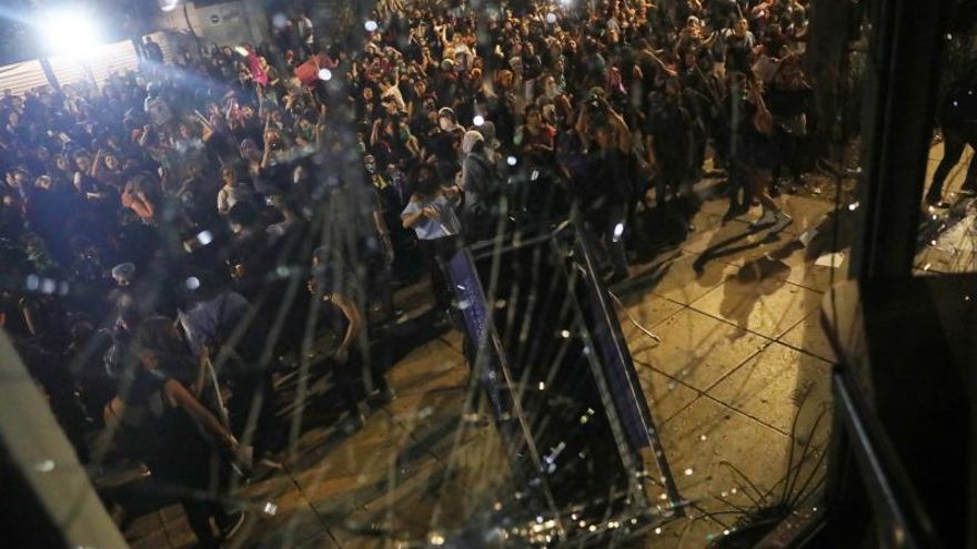 Manifestantes rompen vidrios de un edificio durante una protesta en contra de abusos sexuales por parte de cuerpos policiales este viernes en Ciudad de México (México).