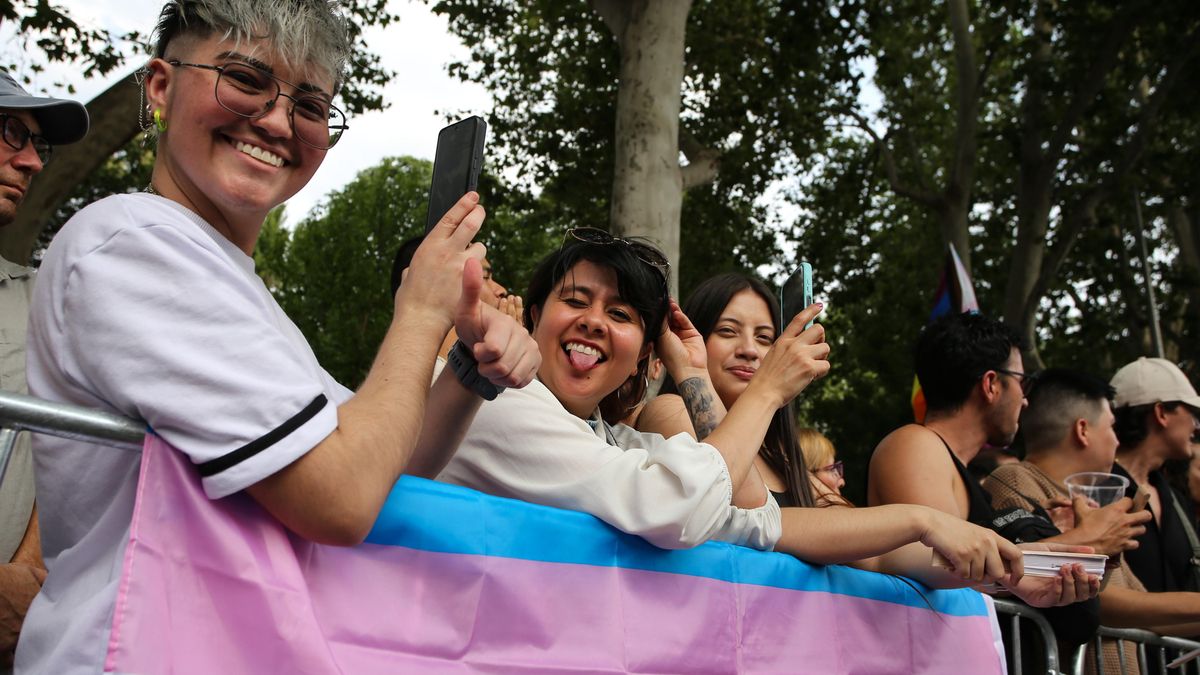 Un grupo de personas posan con la bandera trans