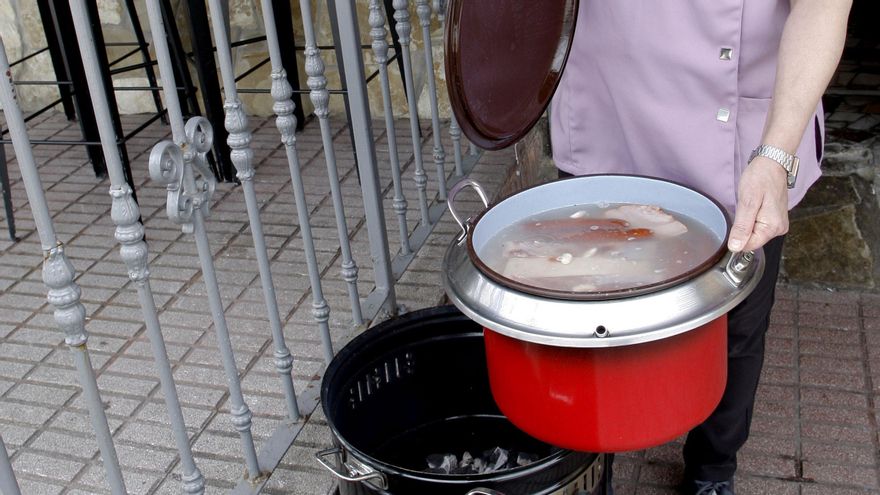 La cocinera Pilar Meana prepara un cocido maragato en olla ferroviaria a las puertas del restaurante avilesino.