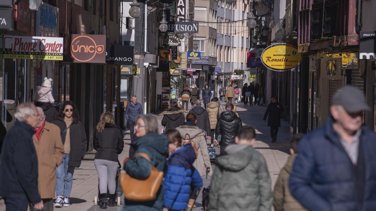 Gente paseando junto a comercios de Torrelavega
