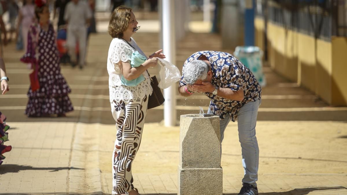 Dos personas refrescándose en la Feria