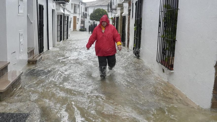 Un vecino de Grazalema (Cádiz) camina por una calle inundada debido a las intensas lluvias que se registran este miércoles en la localidad gaditana.